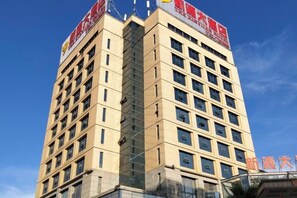 A multi-story hotel building with a clear sky in the background. - Xinyuan Hotel Wanzai (Wanzai)