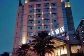 A multi-story hotel building with illuminated windows and a sign indicating it is a hotel. - Xinyuan Hotel Wanzai (Wanzai)
