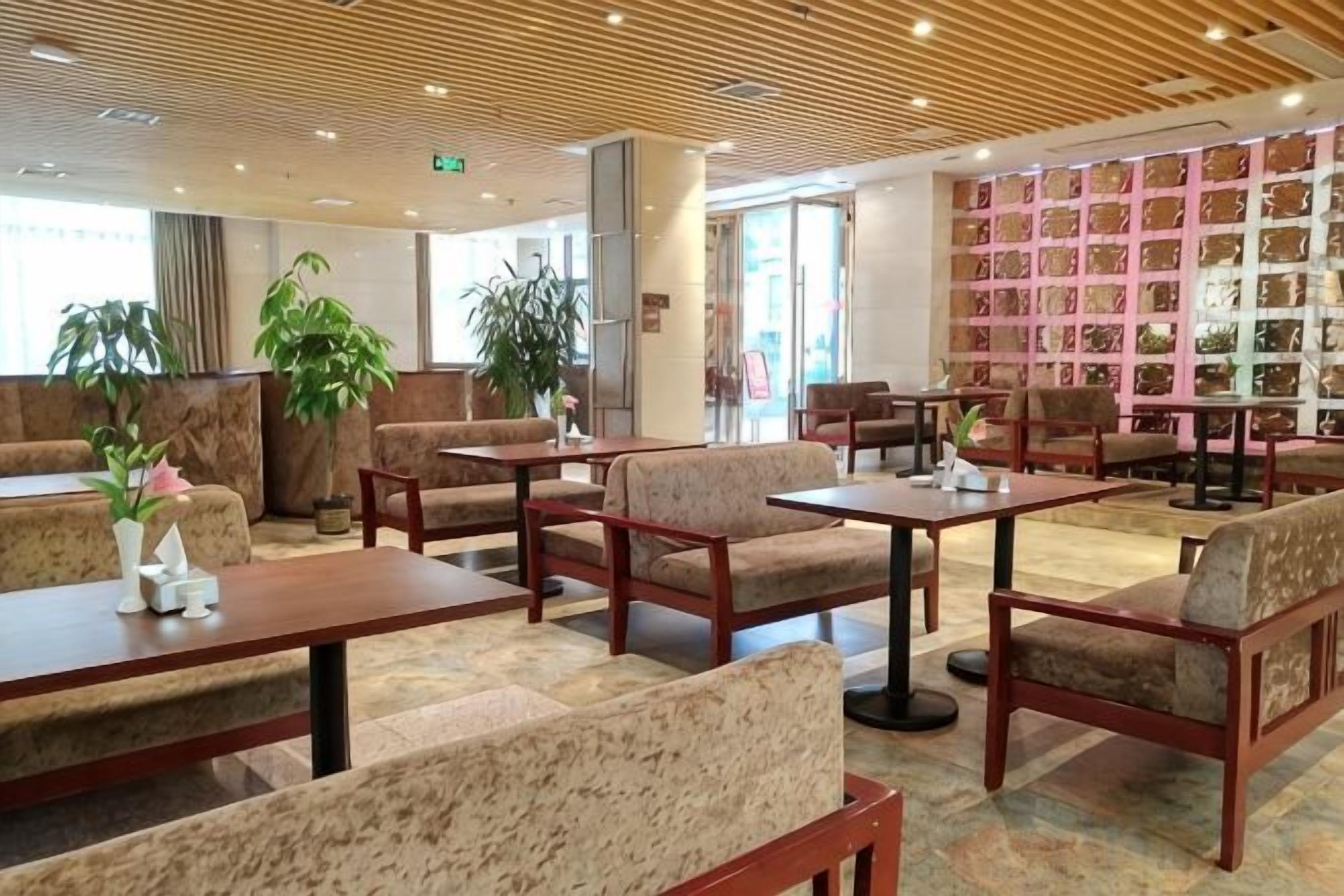 Un hall de hotel con arreglos de asientos, una recepción y una pared de cuadros enmarcados.