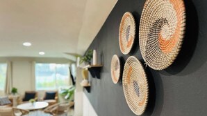 Un interior moderno con una pared oscura decorada con arte mural tejido.