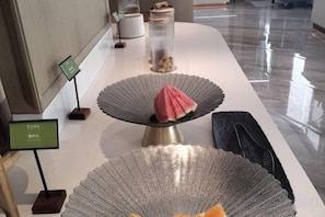 A polished reception area with a reception desk, a glass display case, and a decorative item on a pedestal. - kairuihotel (Jianli)