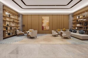 A modern interior with a central seating area, bookshelves, and a large abstract painting. - kairuihotel (Jianli)