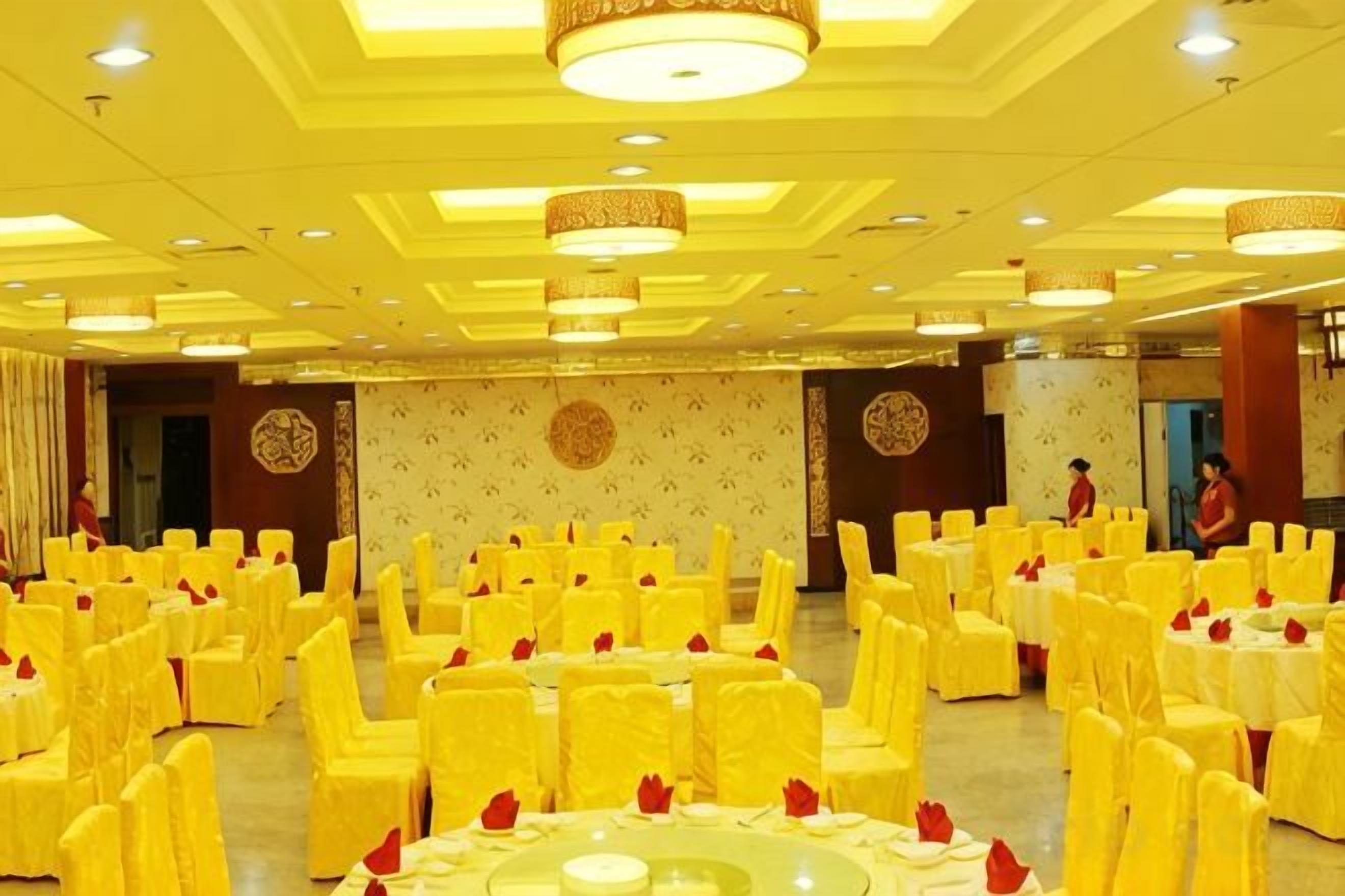A banquet hall with round tables and chairs, arranged in rows.
