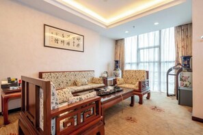 A traditional-style living room with a sofa set, a coffee table, and a decorative vase. - Y. H. Continental Grand Hotel (Jiangle)