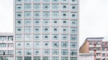 Un edificio de gran altura con una fachada plana y una cuadrícula de ventanas.