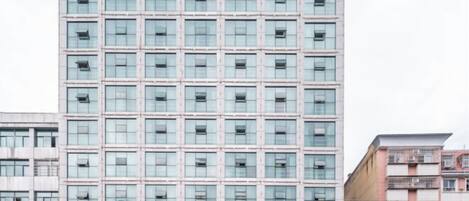 Un edificio de gran altura con una fachada plana y una cuadrícula de ventanas.