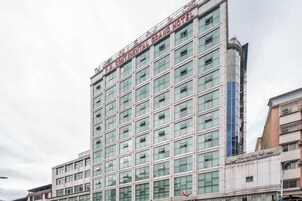 A multi-story hotel building with a modern facade, large windows, and a prominent signage at the top.