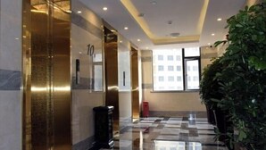 Un vestíbulo de hotel con mostrador de recepción y un amplio ventanal que ofrece vistas del exterior del edificio.