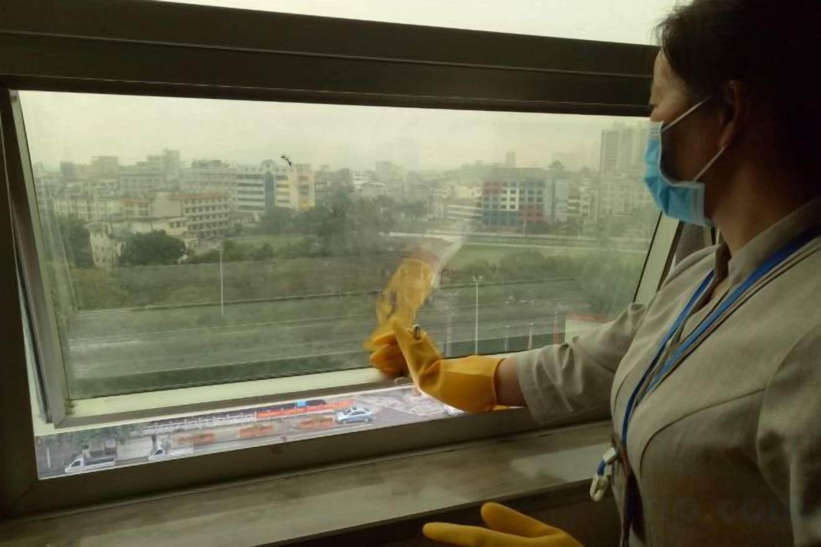 A person cleaning a window with a squeegee.