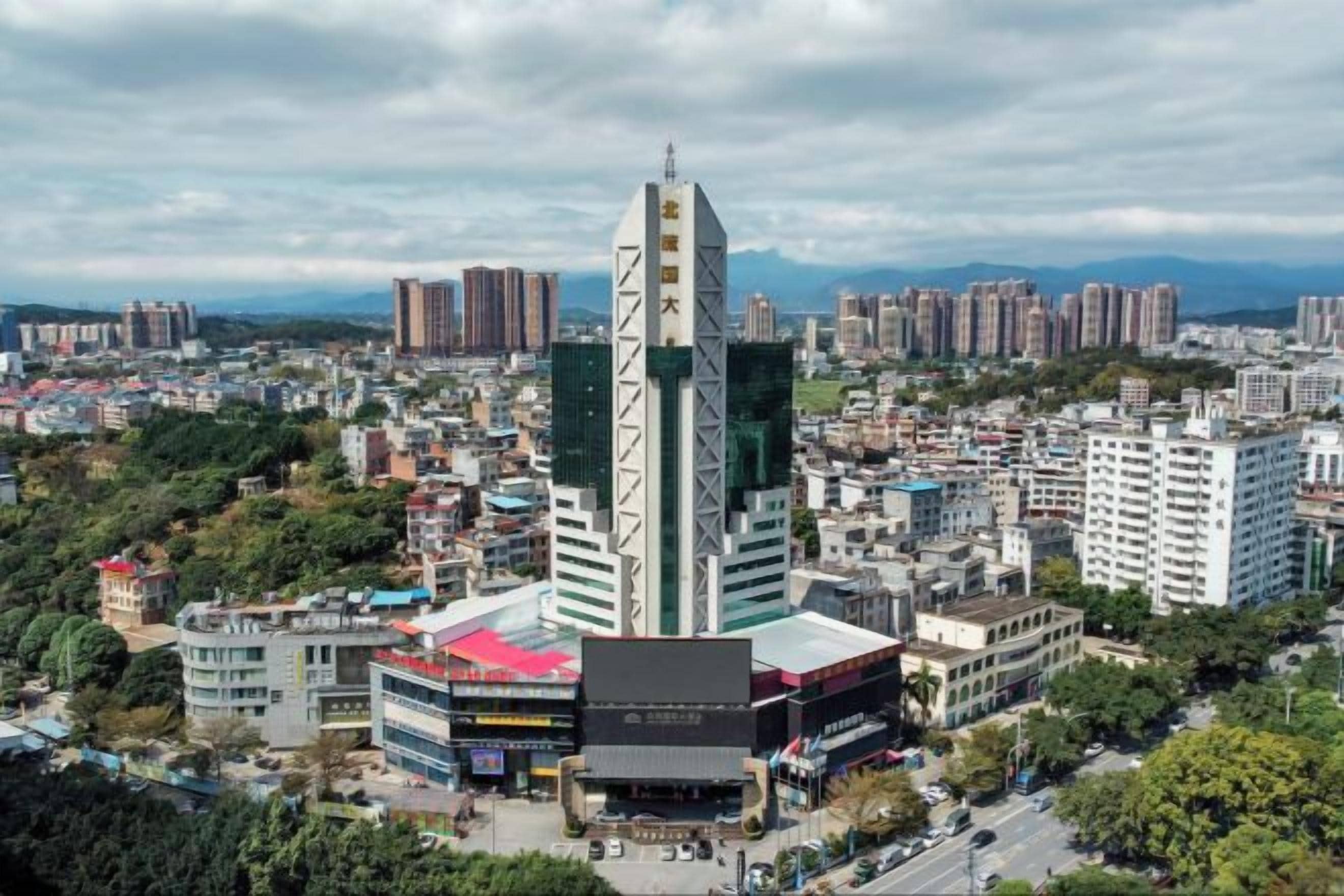 Un paysage urbain avec des bâtiments modernes, dont un gratte-ciel remarquable qui se distingue par son architecture originale.