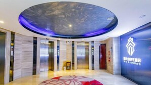 A modern lobby with a circular ceiling design, elevators, and a logo on the wall. - Beiliu International Hotel (Beiliu)