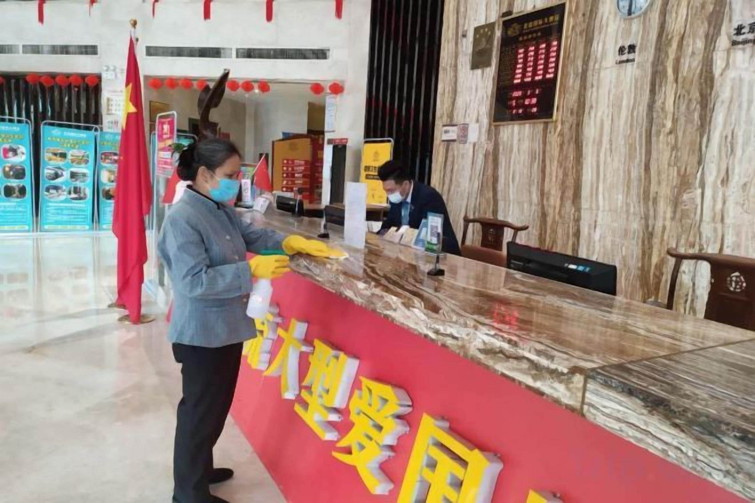 A reception desk with a red banner, a clock, and a digital display.