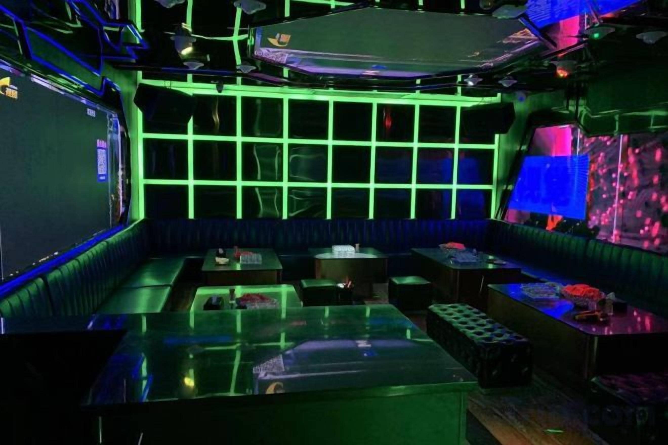 Una stanza con un tavolo in vetro, un divano e una parete illuminata al neon.