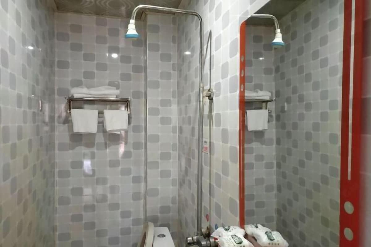 A shower with a glass door, a towel rack, and a mirror.