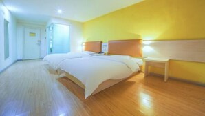 A hotel room with a large bed, bedside tables, and a door leading to another room. - 7 Days Holiday Hotel (Guiyang Gaicha Avenue Zhongshan Middle Road) (Guiyang)