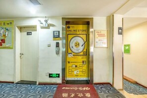 An elevator with a yellow sign indicating an online store and a 24-hour service. - 7 Days Holiday Hotel (Guiyang Gaicha Avenue Zhongshan Middle Road) (Guiyang)
