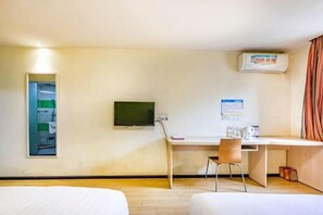 A hotel room with a bed, a desk with a chair, a television, and a wall-mounted air conditioner. - 7 Days Holiday Hotel (Guiyang Gaicha Avenue Zhongshan Middle Road) (Guiyang)