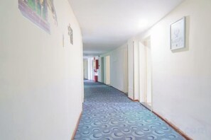 A hallway with patterned carpet, white walls, and doors leading to other rooms. - 7 Days Holiday Hotel (Guiyang Gaicha Avenue Zhongshan Middle Road) (Guiyang)