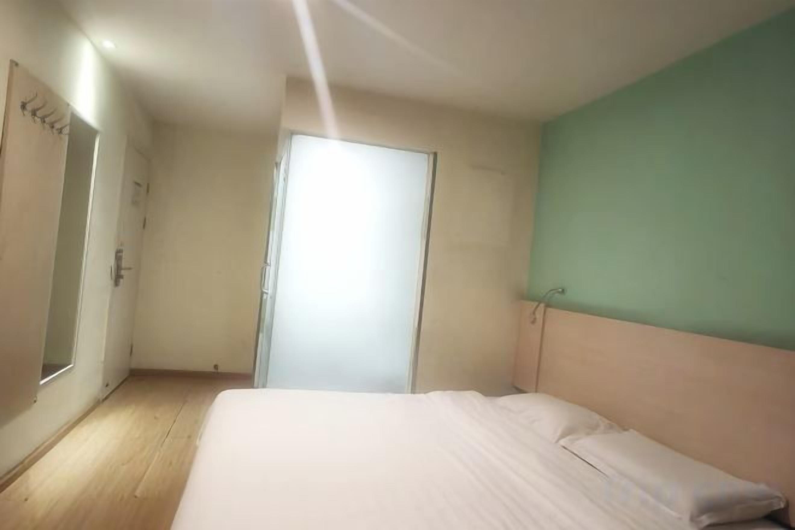 Une chambre à coucher avec un lit, une armoire et une porte.