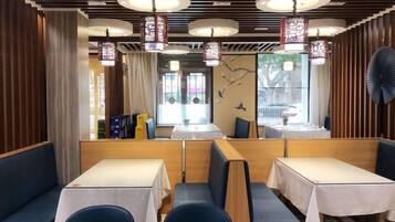 A restaurant interior with booths, tables, and hanging lanterns.