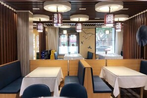 A restaurant interior with booths, tables, and hanging lanterns. - Pebble Motel (Jiusan Road Bus Station, Lvshun) (Dalian)