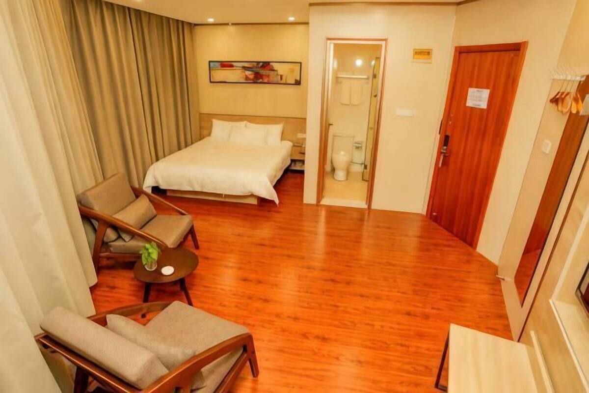 Ein Hotelzimmer mit einem Bett, einer Couch, einem kleinen Tisch und einer Tür zu einem Badezimmer.