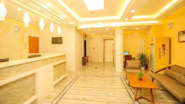 A hotel lobby with a reception desk, seating area, and a large plant. - Pebble Motel (Jiusan Road Bus Station, Lvshun) (Dalian)