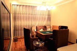 A room with a pool table, four chairs, a small table with a basket, and a mirror on the wall. - Xichong Mingcheng Holiday Hotel (Nanchong)