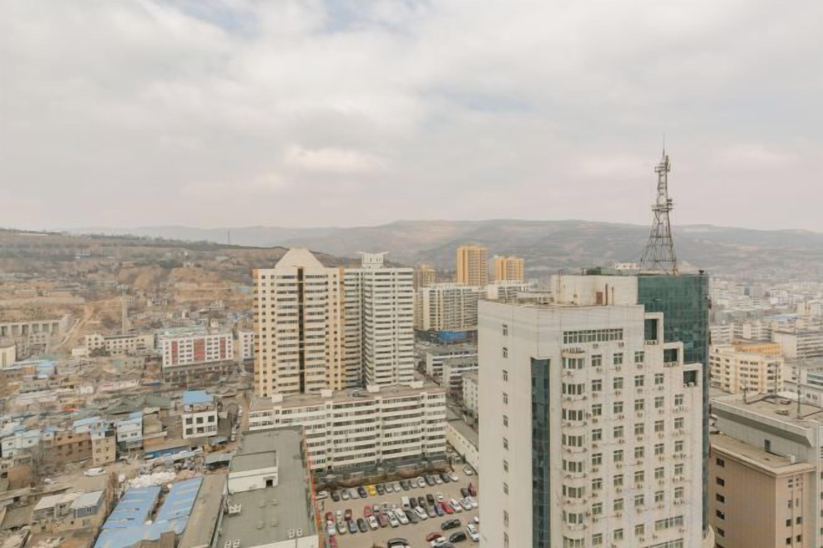 Panorama urbano con numerosi grattacieli, tra cui una torre imponente con guglia.