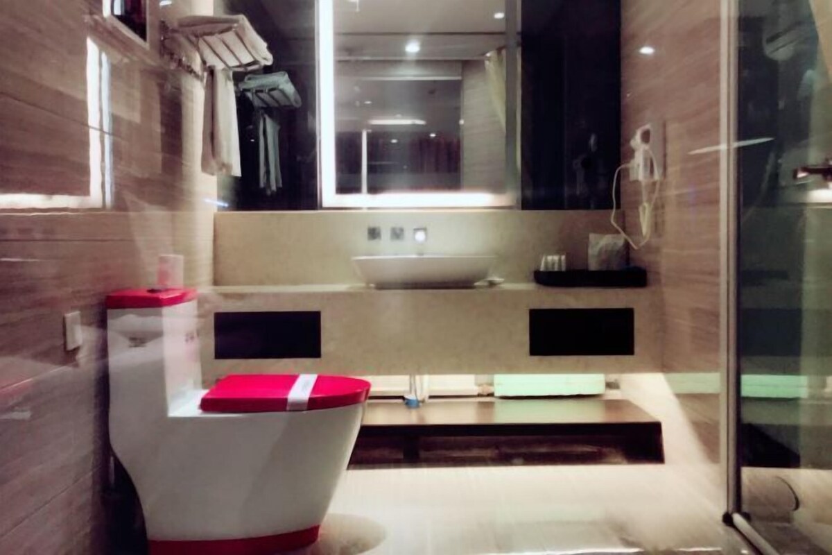 A modern bathroom with a toilet, sink, and shower area.