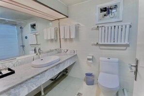 A bathroom with a marble sink, a toilet, a towel rack, a radiator, and a trash bin. - Jinlong Hotel (Tianshui)