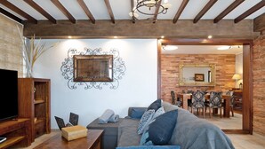 A living room with a sofa, wooden coffee table, and a TV stand.