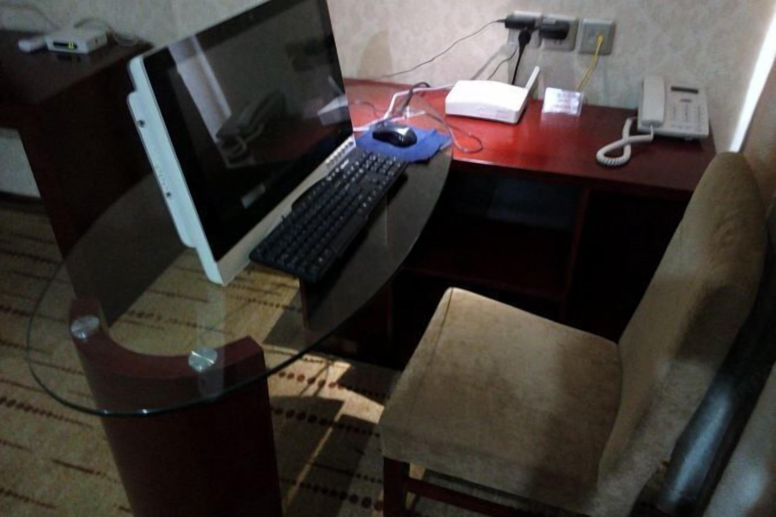 A desk with a laptop, a telephone, and a power strip.