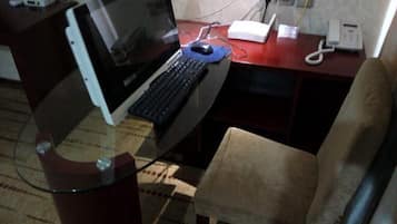 A desk with a laptop, a telephone, and a power strip.