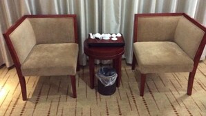 Two armchairs with a small table and a trash can between them. - Lijing Hostel (Fuzhou)