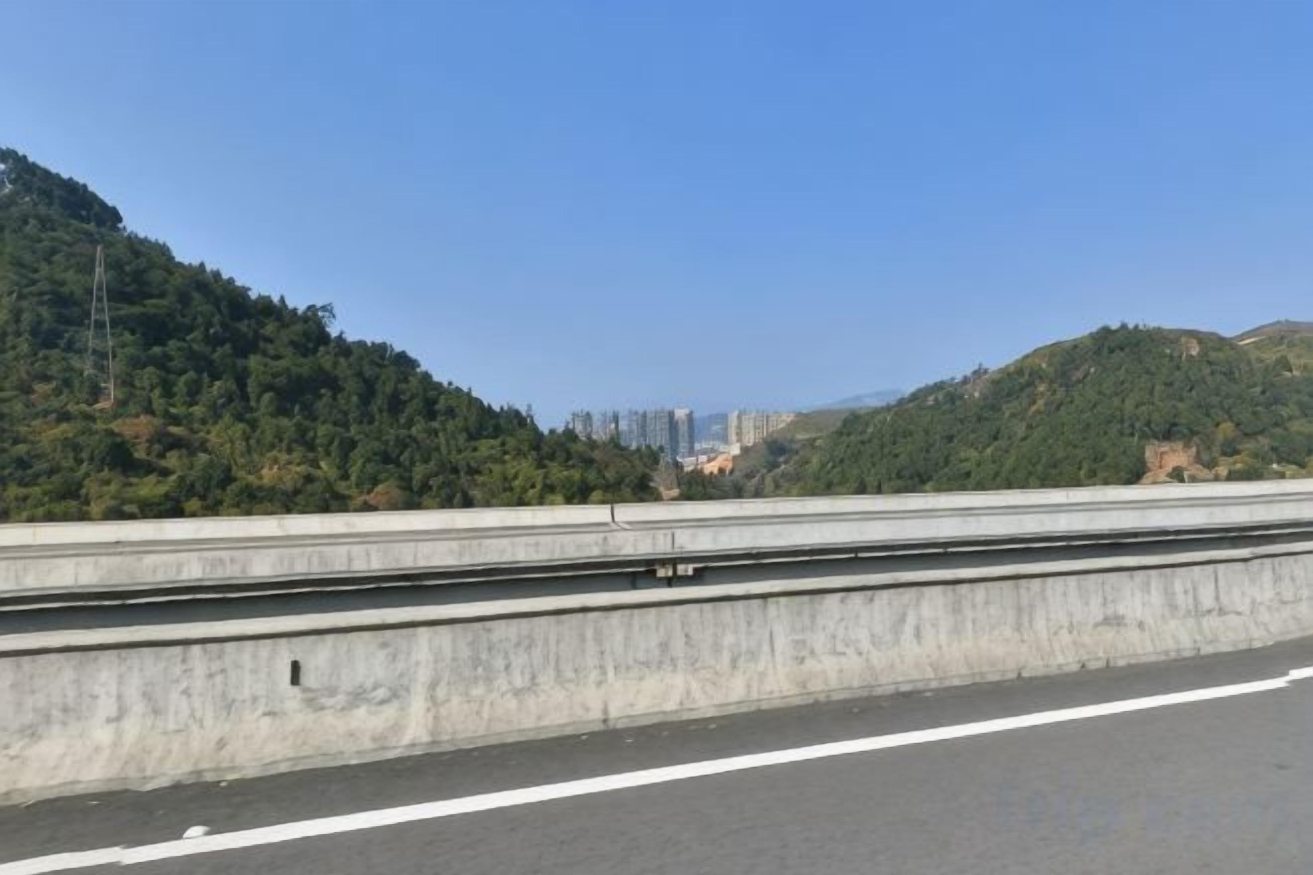 Eine Autobahn mit Betonleitplanken und blauem Himmel.