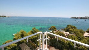 A coastal view from a balcony with clear turquoise sea, boats, and a tree-lined shoreline. - Dream Luxury Beach Front Majestic Sea-views (Palmanova)
