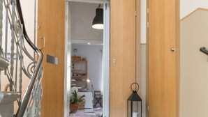 A staircase leading to a room with wooden doors and a metal railing.