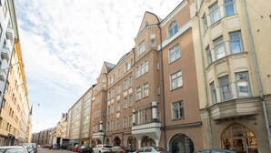 A row of multi-story buildings with a consistent architectural style, featuring large windows and a central entrance.