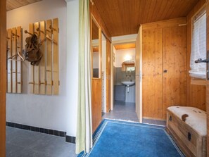 A wooden interior with a bathroom visible through an open door, featuring a sink and mirror. - Phipalo by Interhome (Ovronnaz)