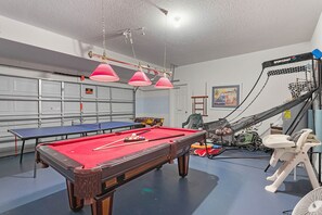 A pool table with red felt, a ping pong table, and a small basketball hoop. - CHARMING OASIS VILLA NEAR DISNEY WITH POOL, BBQ, AND OUTDOOR ADVENTURES (Clermont)