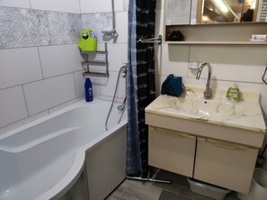 A bathroom with a bathtub, a sink with a mirror above it, and a shower curtain. - Family -ONLY- welcome to Berching (Berching)