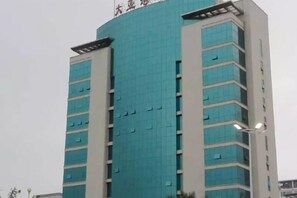 A multi-story building with a blue facade and a series of windows on each floor.
