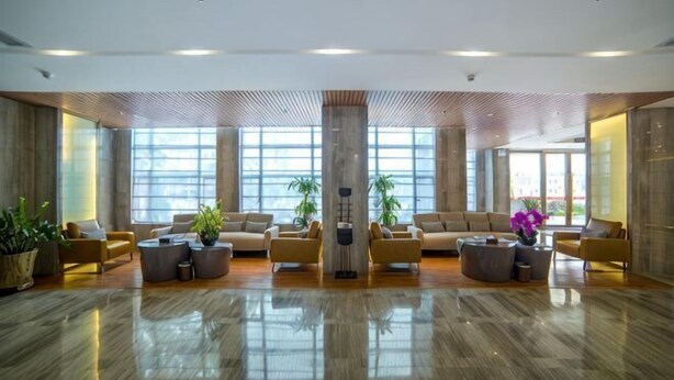 A spacious lobby with a polished wooden floor, large windows, and several seating areas. - Shuang Yi Hotel (Huizhou)