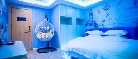 Een moderne slaapkamer met een bed, een hangstoel en een houten deur.