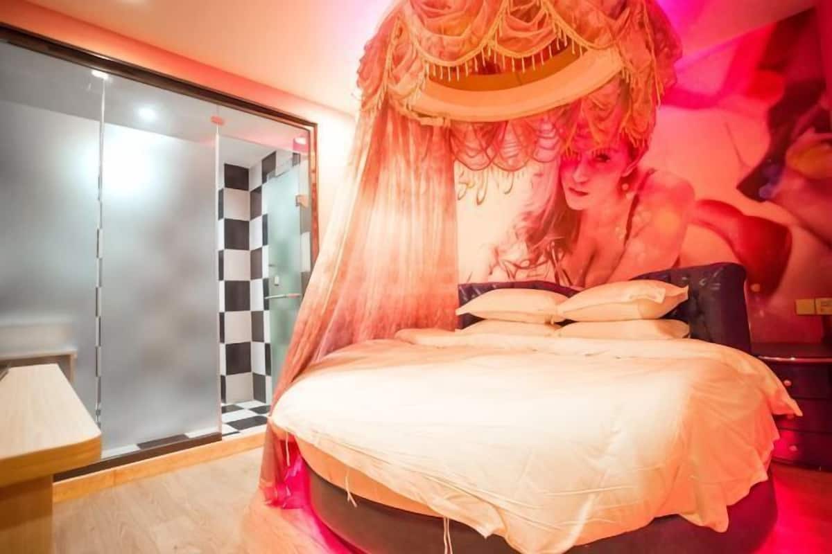 Un dormitorio con cama, mesita de noche y armario con estampado de cuadros.
