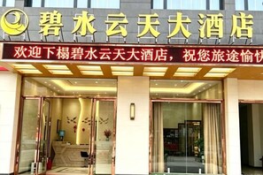 A hotel entrance with a signboard, glass doors, and a reception desk. - Bishui Yuntian Hotel (Yunyang County)