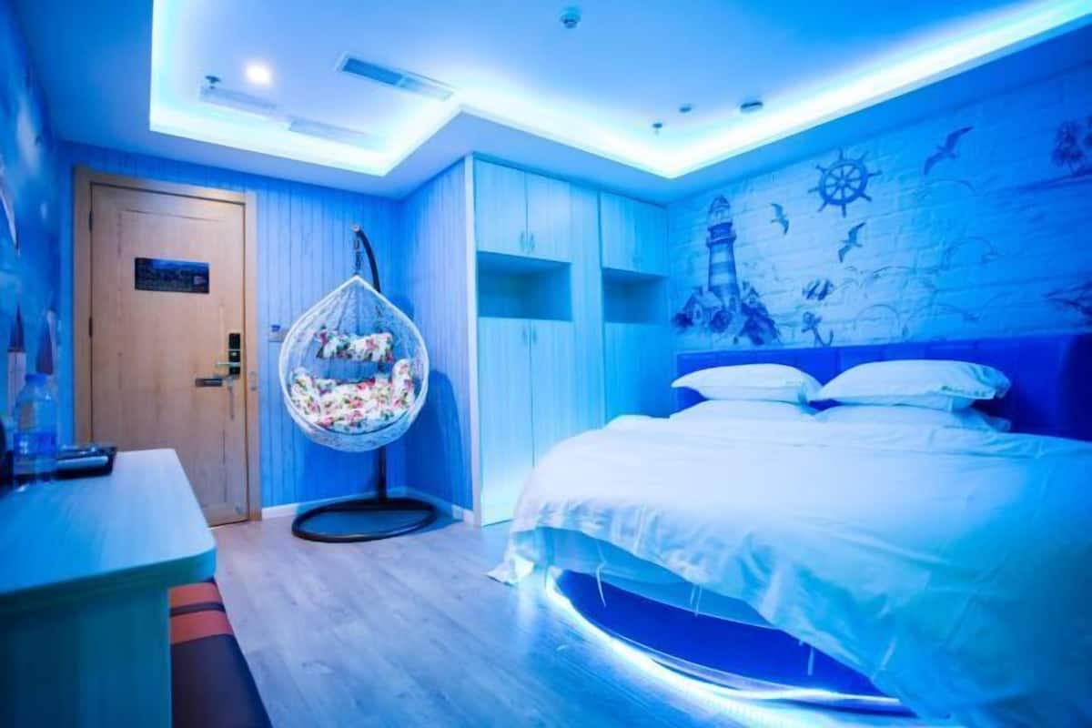 Un dormitorio con cama, una silla colgante y un armario.