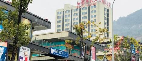 A multi-story building with signage indicating a hotel and various businesses.