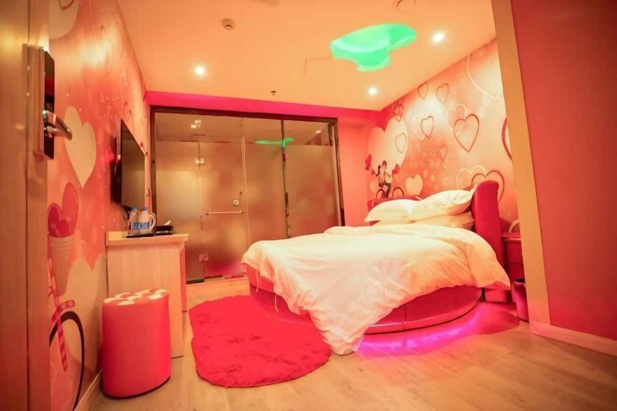 Un dormitorio con cama, escritorio, espejo y armario.